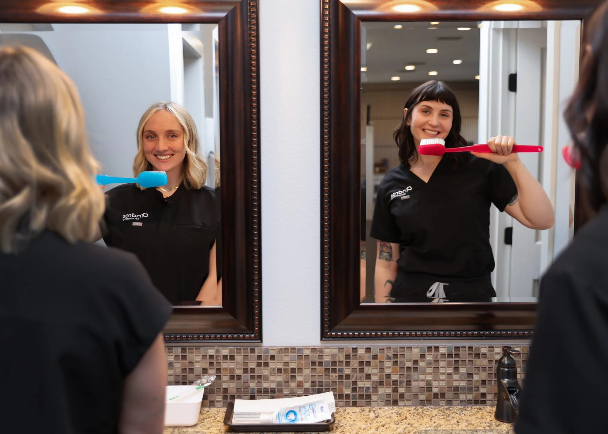 Two Andros Orthodontics team members at the patient brushing station